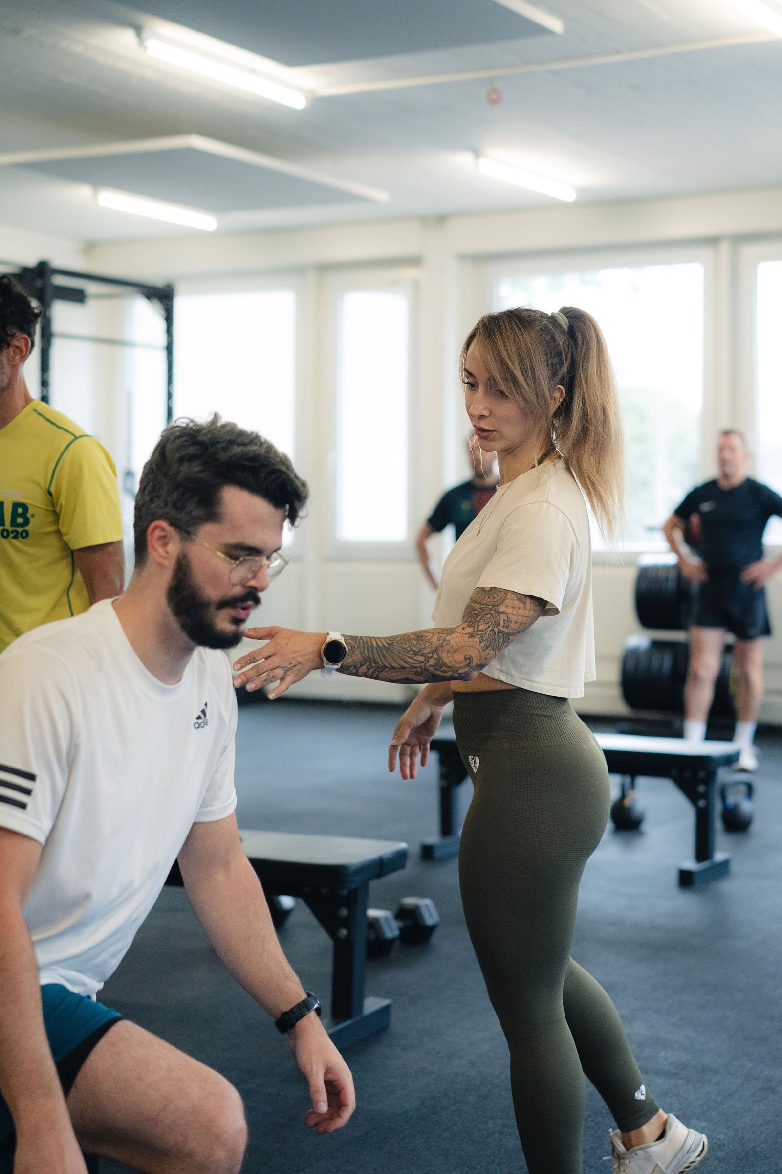 Coach corrigeant la posture d'un pratiquant au studio